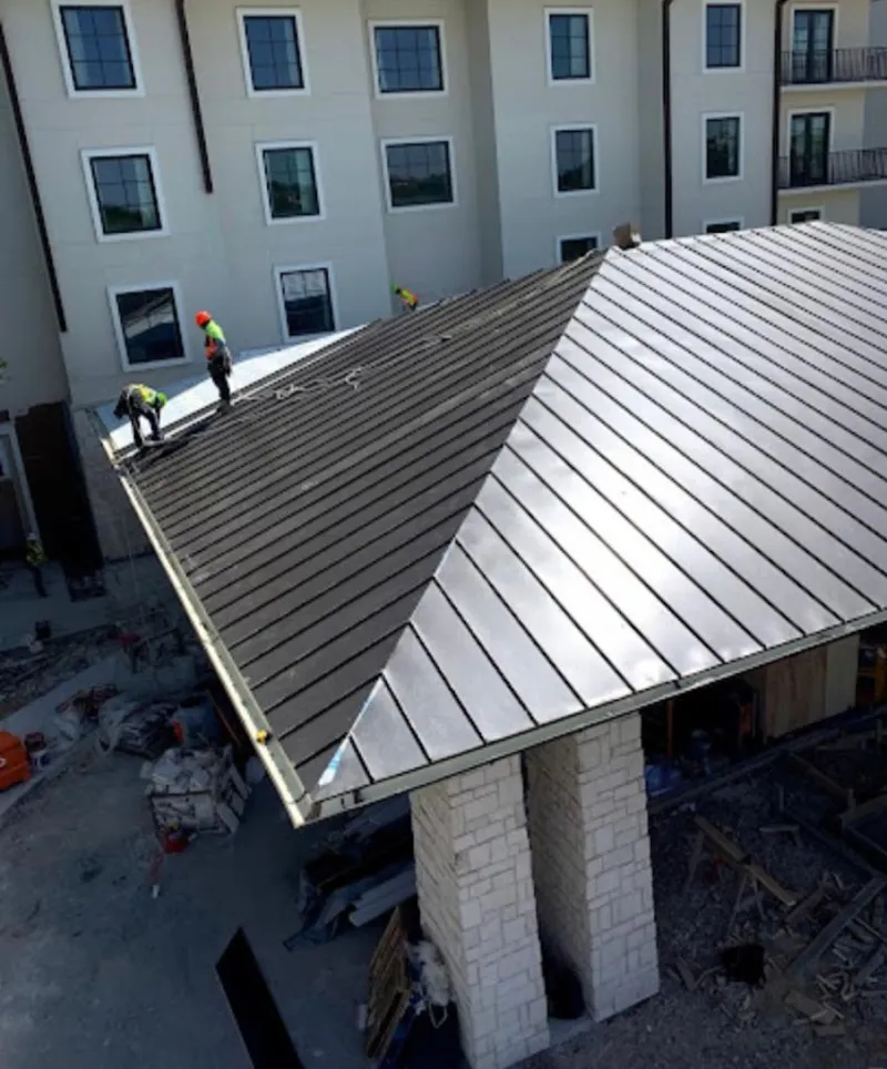 Crew installing standing seam metal roof panels on a commercial project in Grovetown